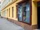 Schaufenster des MILA Mitmach-Supermarkt, Gehsteig und gelber Hausfassade